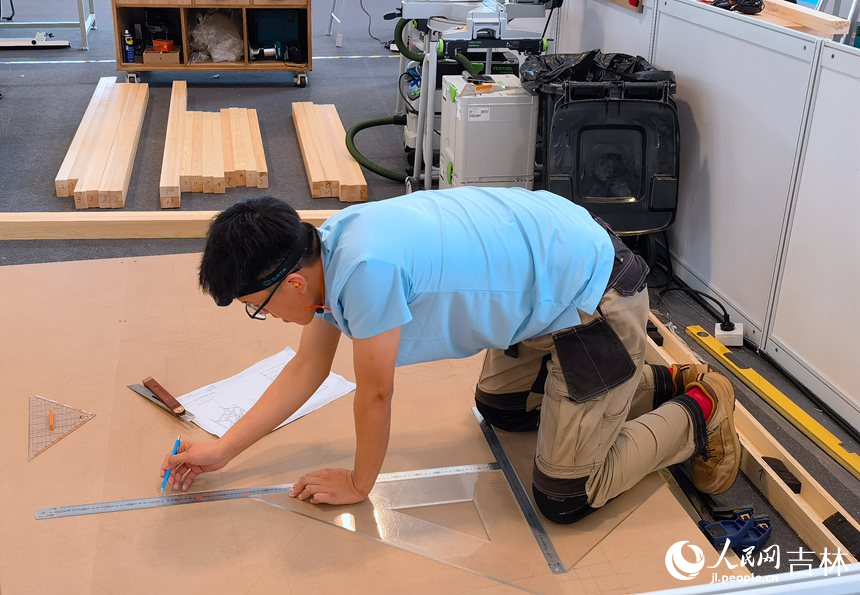 木工賽項選手陳俐志進行測量繪制。人民網記者 馬俊華攝