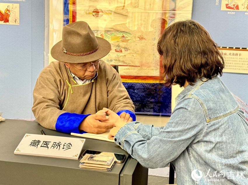 西藏自治區藏醫院藏醫主任醫師尼瑪為觀眾脈診、講解藏藥知識。人民網記者 李思玥攝