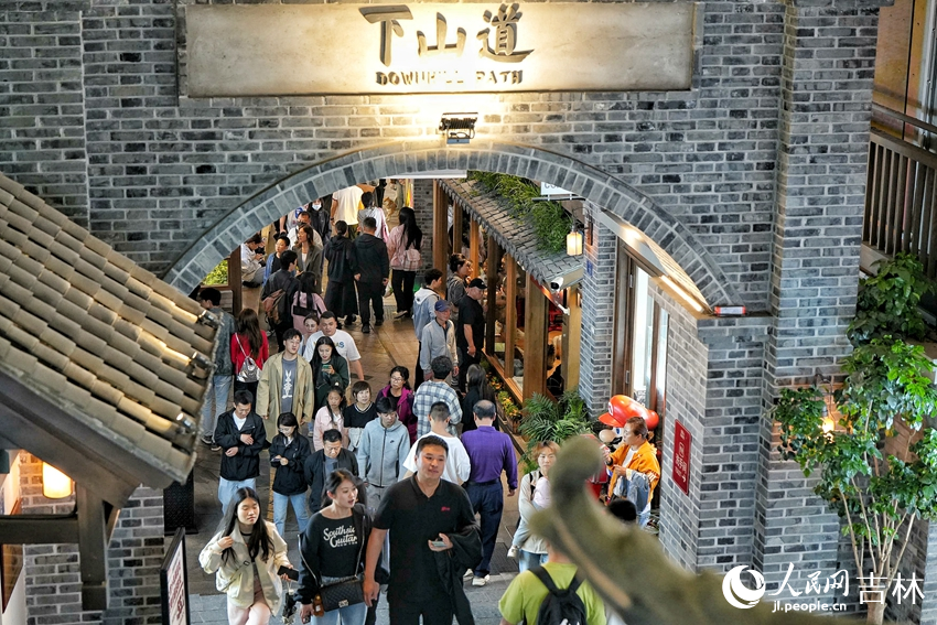 夜色降臨，游客在位于長春市的“這有山”文旅小鎮逛街購物。人民網記者 李洋攝