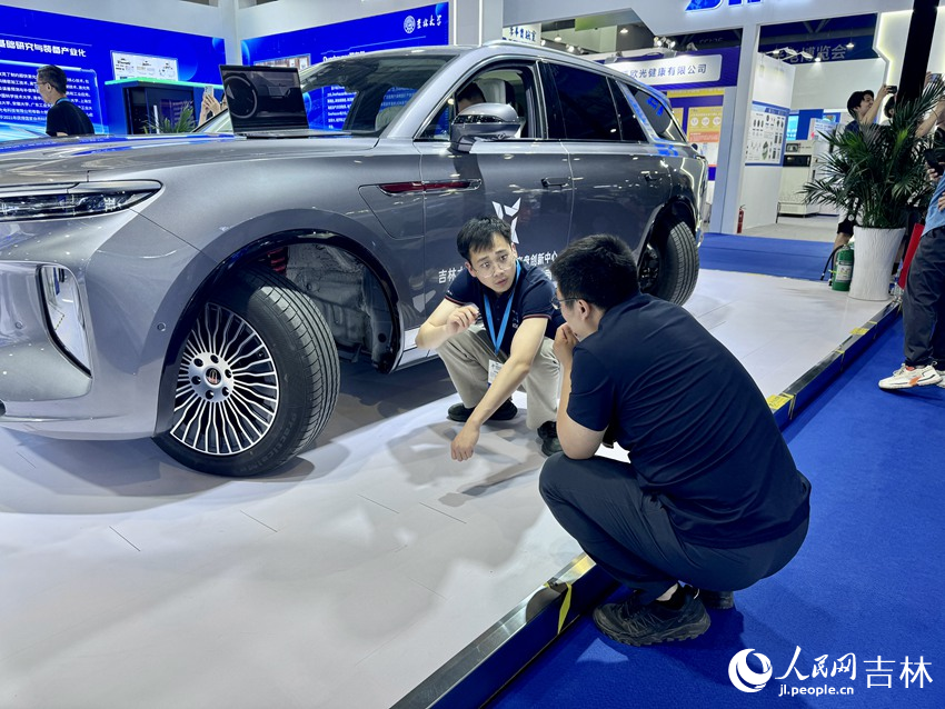 吉林大學研發團隊成員正在向觀展者介紹自動輪智行底盤技術。人民網記者 李思玥攝