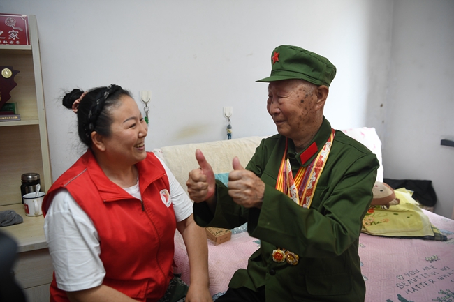 老兵朱萬金向關愛老兵志愿者表達感謝。