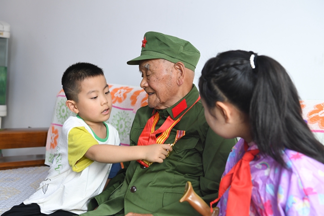老兵李文惠為孩子講述自己的戰斗故事。