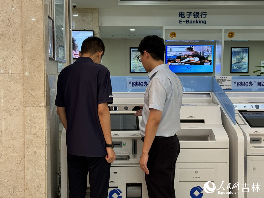建行吉林省分行工作人員為群眾演示“稅銀e辦”自助辦稅終端操作。人民網記者 李思玥攝