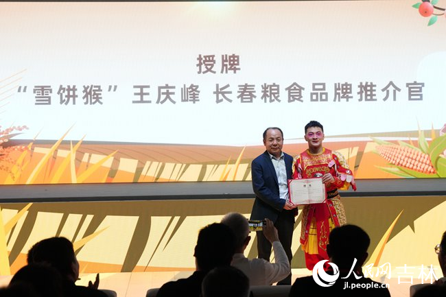 人民網股份有限公司吉林分公司總經理謝龍為“雪餅猴”王慶峰授牌