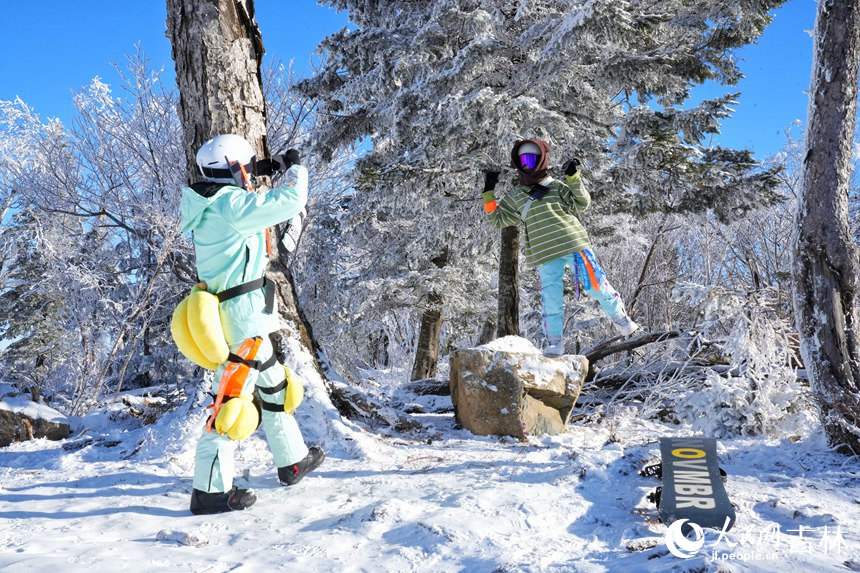 游客在北大湖霧凇景觀旁留影。人民網記者 李洋攝