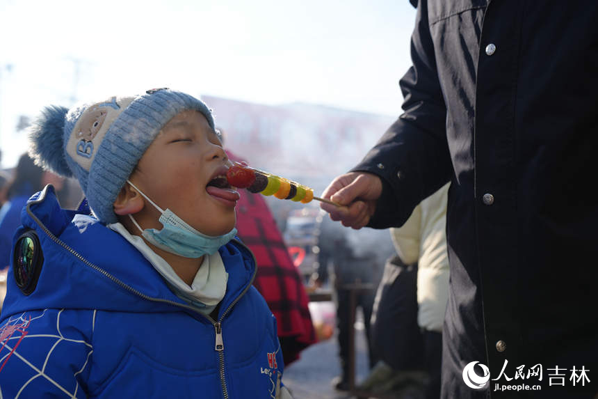 小朋友在大集上品嘗香甜的糖葫蘆。人民網記者 李洋攝