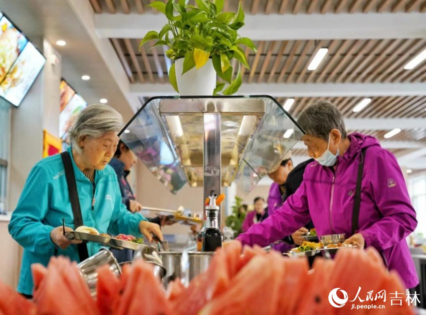 長春市飛躍街道三佳社區敬老餐廳內，市民正在選取午餐。人民網記者李洋攝