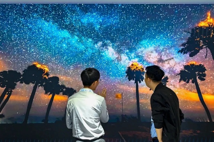 長春光博會希達電子展區，一位工作人員正在給一位觀眾講解。（長春新區供圖）