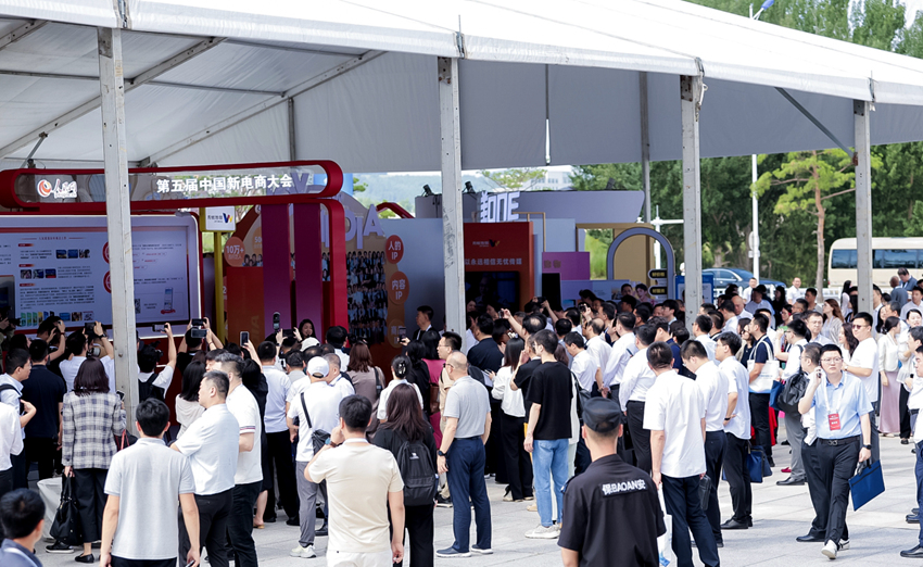 開幕式前，與會嘉賓在人民優選、抖音等展位前，與工作人員交流新電商發展（主辦方供圖）