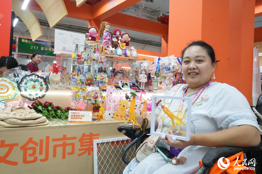一名“巧姐”展示著她創作的工藝品。人民網記者 李洋攝