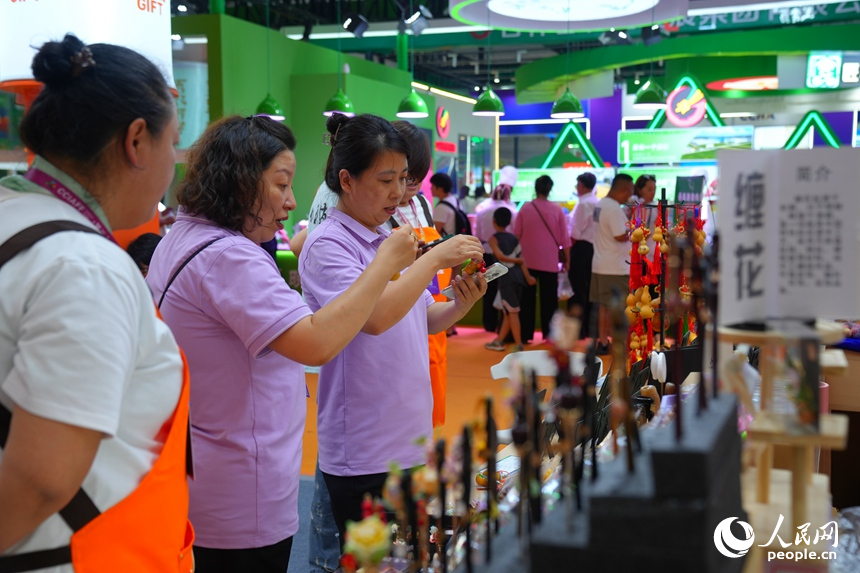 游客在“吉林巧姐”展區欣賞精美的工藝品。人民網記者 李洋攝