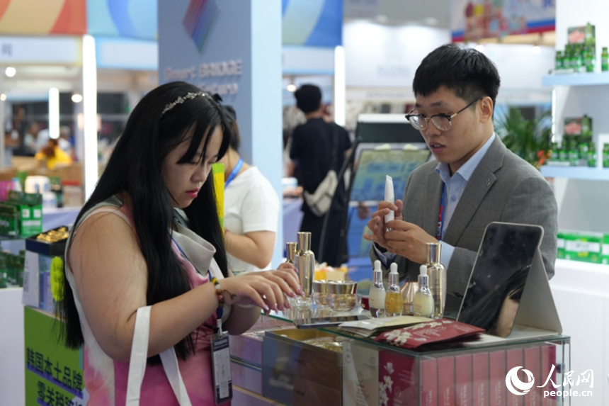 一名游客在第十五屆中國—東北亞博覽會上試用韓國化妝品。人民網記者 李洋攝
