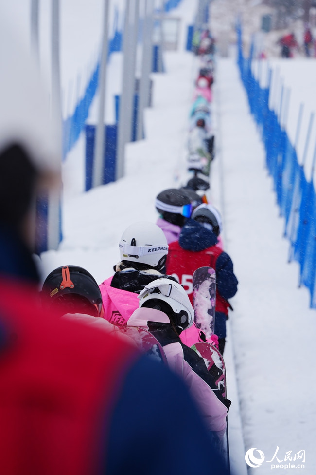 11月27日，滑雪愛好者在長白山和平滑雪場依次排隊進入魔毯。人民網記者 李洋攝