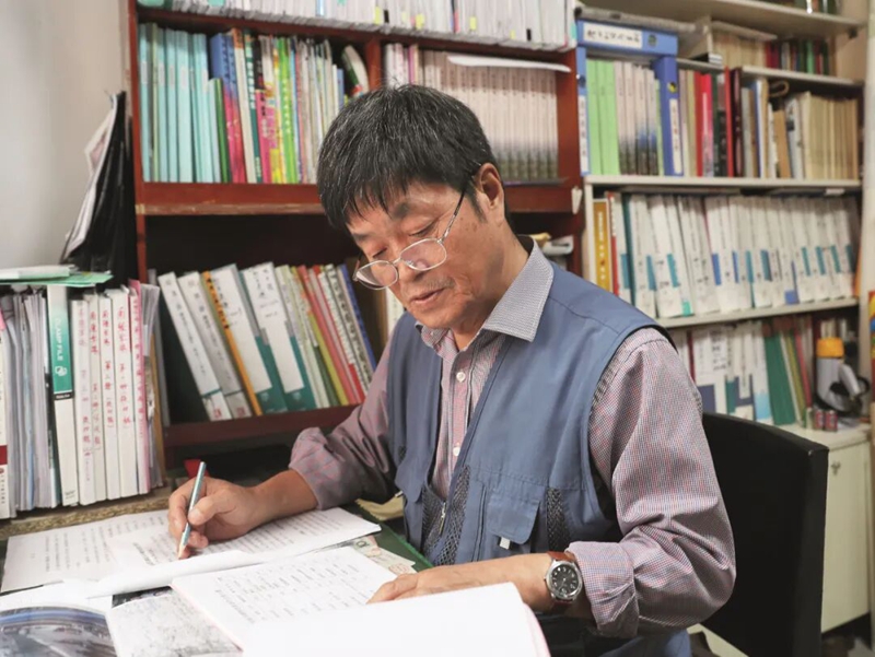 金萬春在翻閱認真查找烈士資料