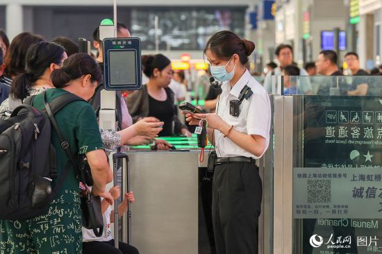 2023年10月1日，上海虹橋站，鐵路工作人員正在人工檢票。 人民網記者 王初攝